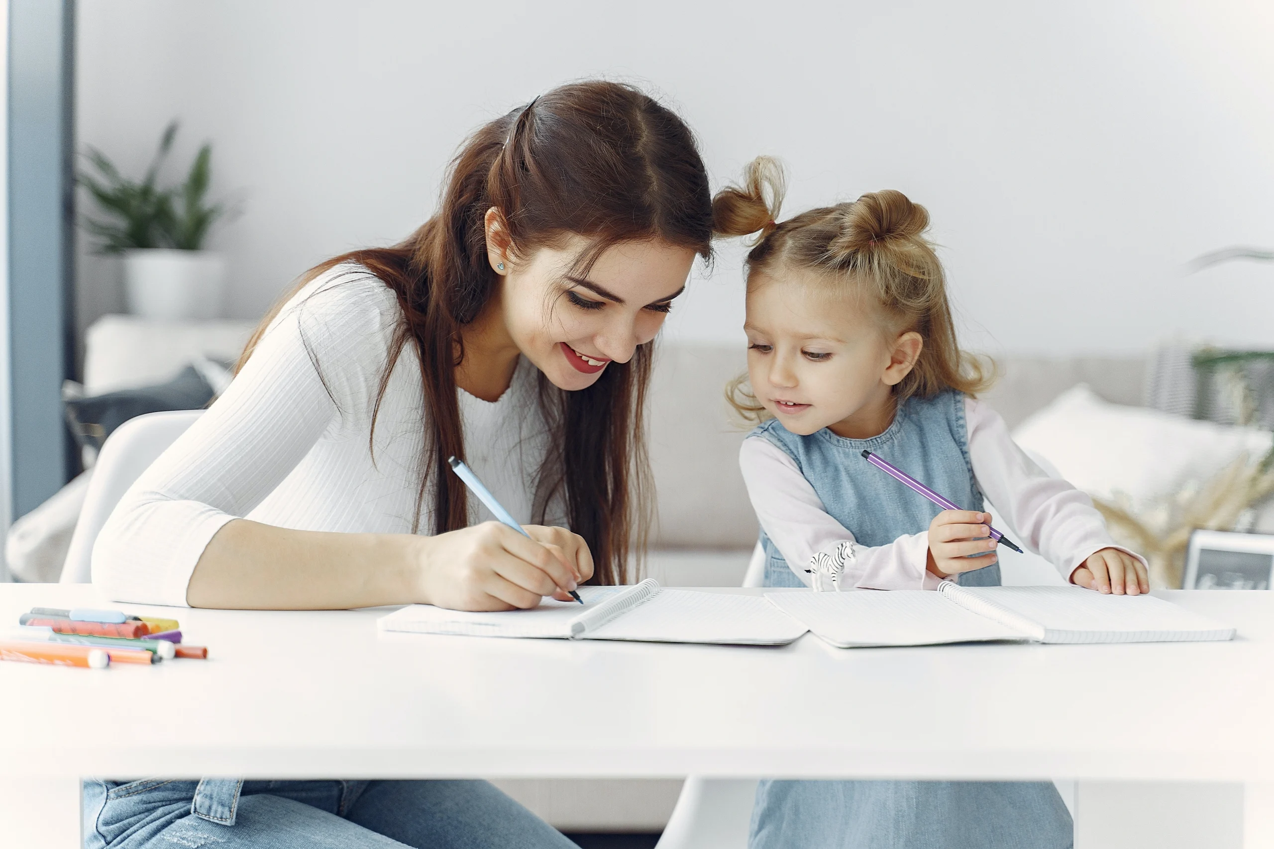 Une maman aide sa fille à faire ses devoirs
